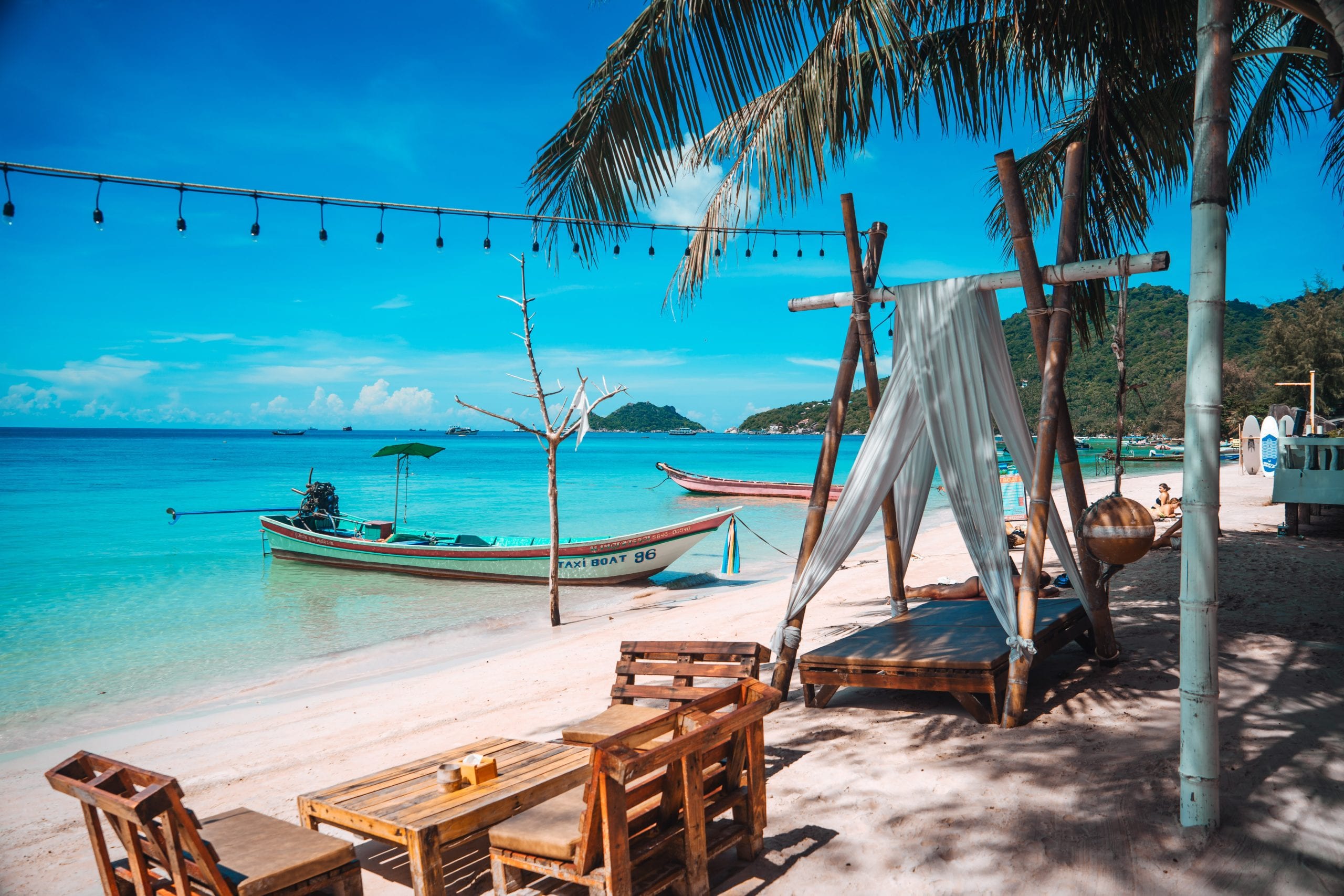 A Koh Tao beach bar lighting up as the sun goes down